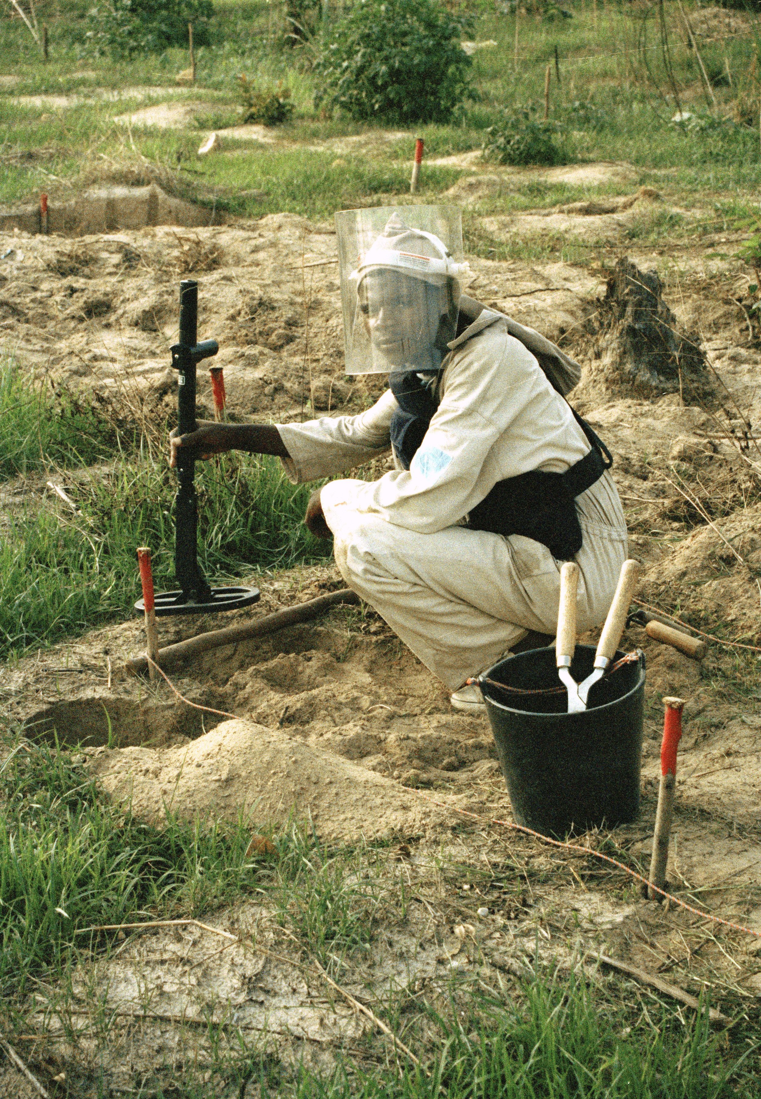 A young man demonstrating the method involved to deactivate a mine. 11 August 1995 Kuito, Angola. UN Photo/John Charles Monua