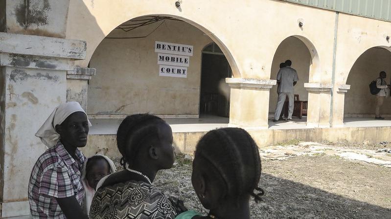 Women sitting on a bench in front of Bentiu's mobile court
