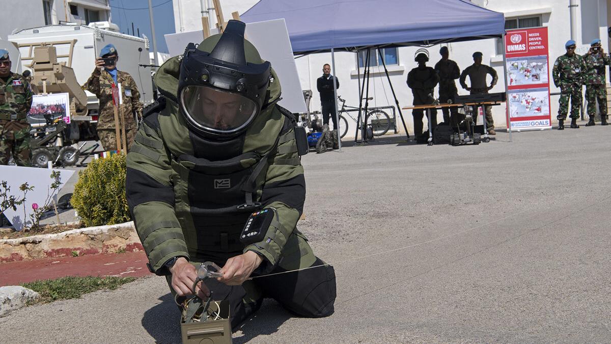 A deminer demonstrates disposal of an improvised explosive device (IED).