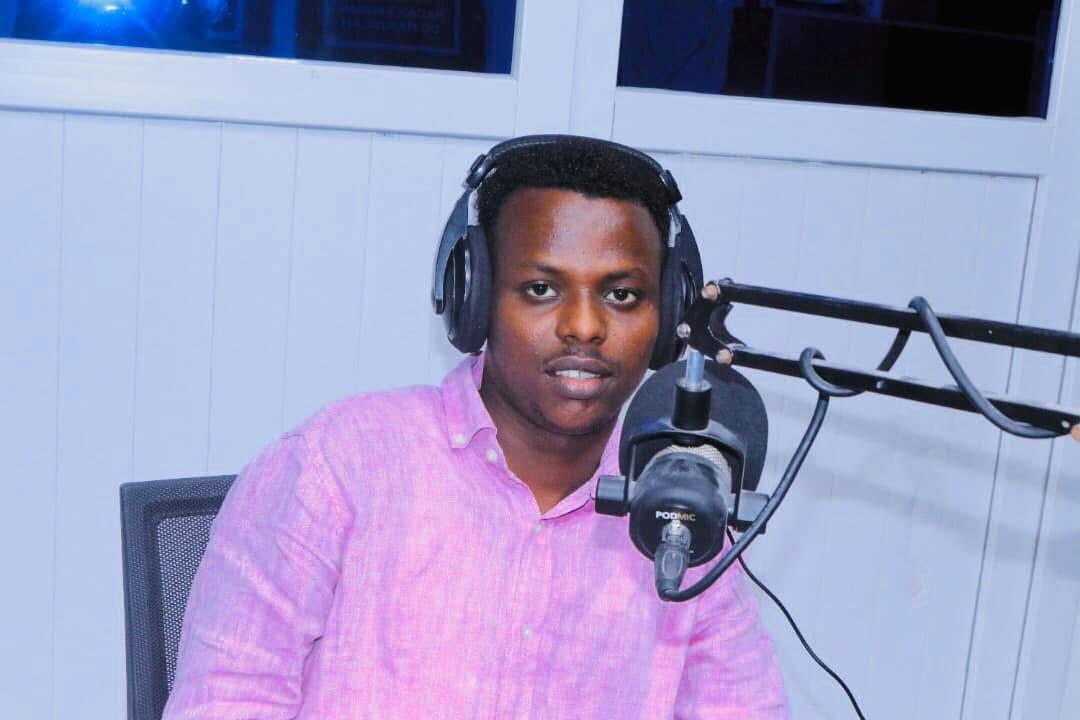Abdishakur Abdirahman in front of a microphone wearing headphones