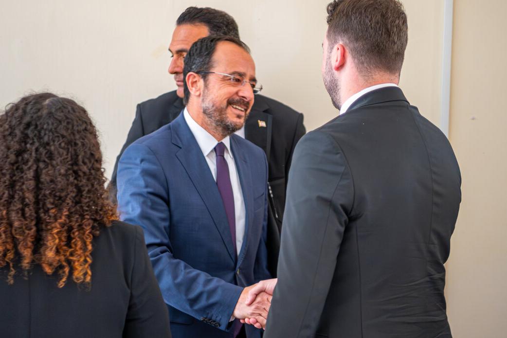 The Greek Cypriot leader, Nikos Christodoulides, shakes his hand.