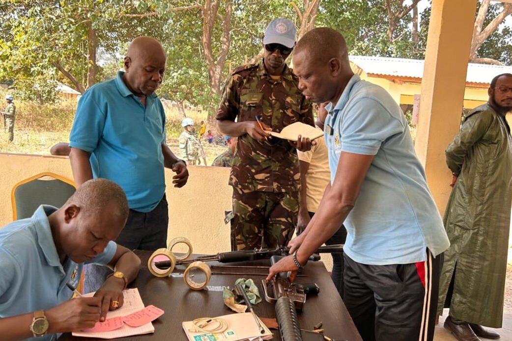 Des Casques bleus et des membres de la communauté se tiennent autour d'une table, travaillant