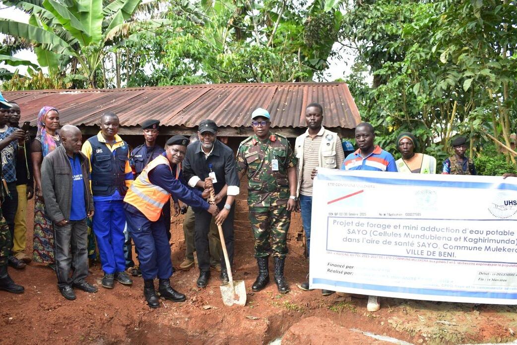 Un groupe pose pour une photo commémorative à l'extérieur.