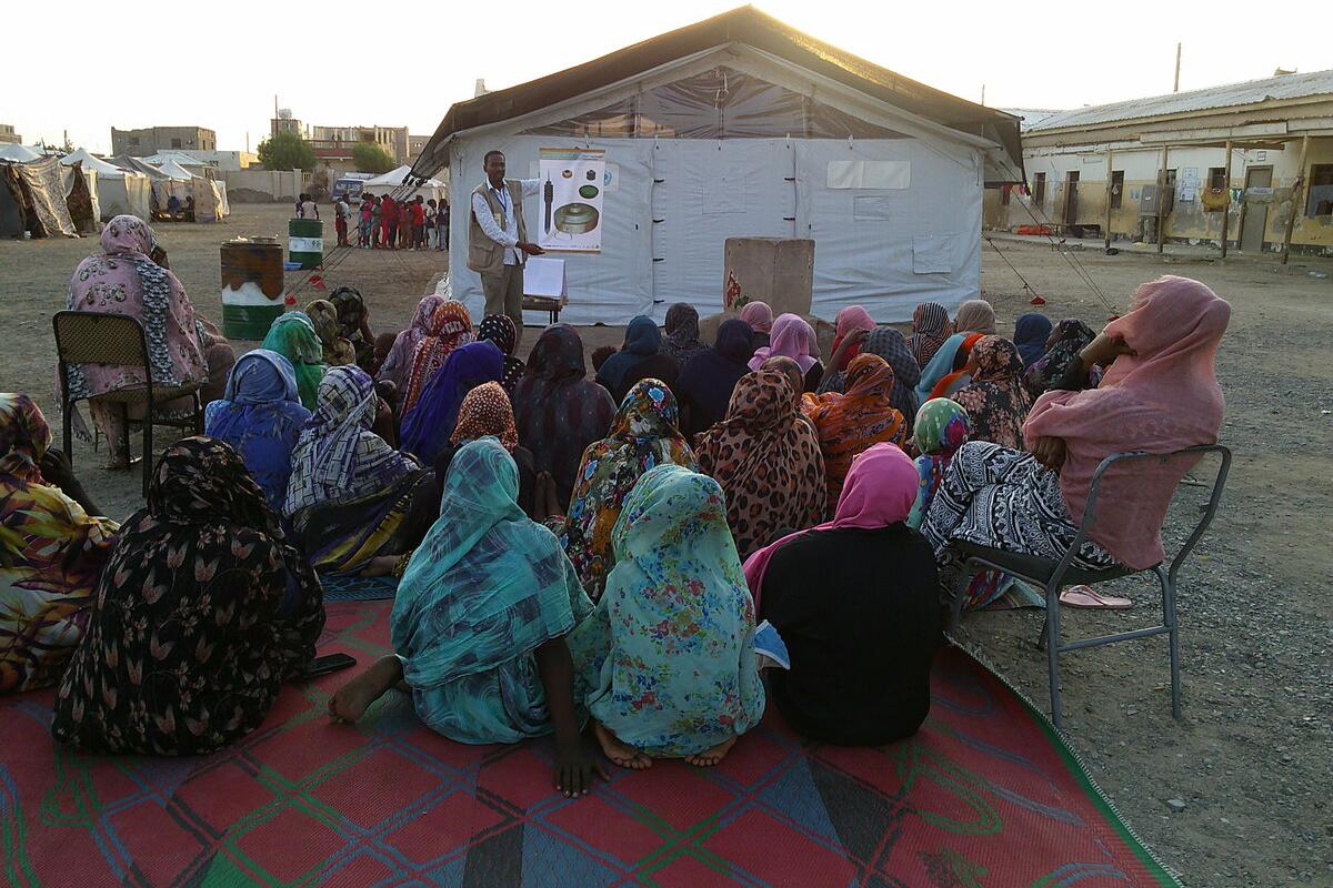a man is presenting a poster to villagers