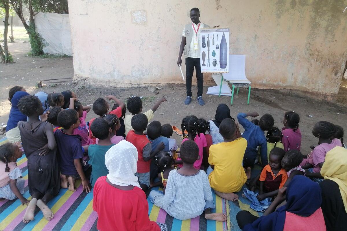 a man is presenting a poster to a group of children