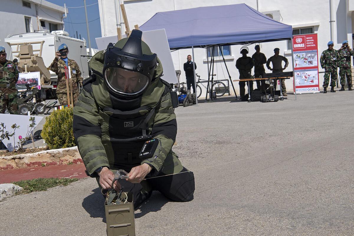 A deminer demonstrates disposal of an improvised explosive device (IED).