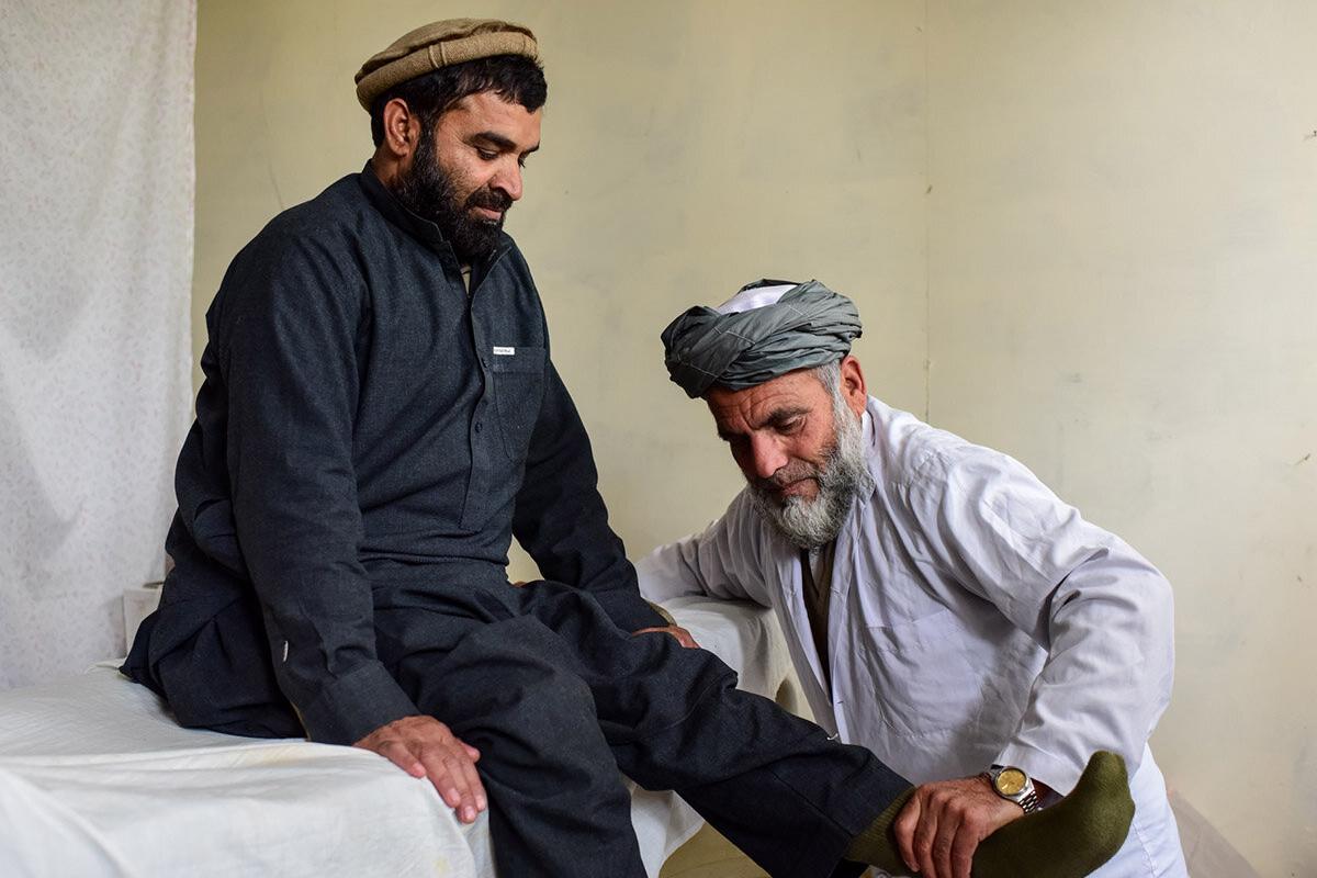 a doctor is conducting physical therapy to a mine victim