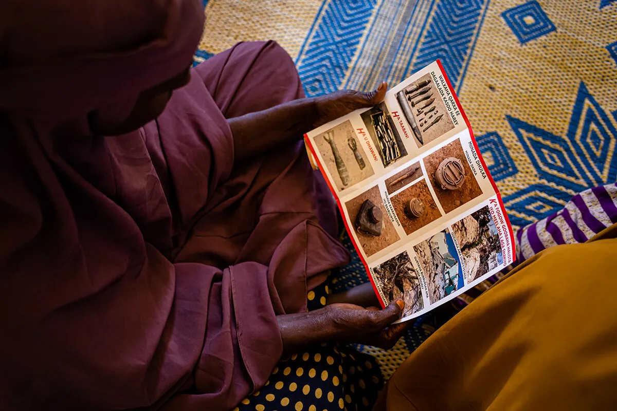 a woman is holding and reading a flyer