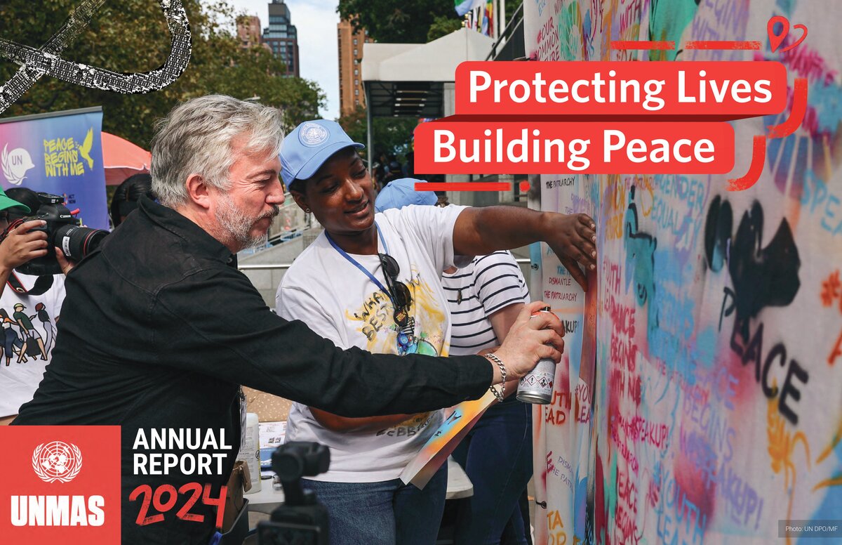 UNMAS Annual Report 2024, Protecting Lives, Building Peace. The cover photo is a woman holding a stencil against a canvas and a man spray painting the canvas through the stencil.