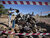 An operator from TDI, UNMAS implementing partner, throws metal scraps, found during Battle Area Clearance (BAC) activity, in the UXO and scrap collection pit at the Malian Army (FAMA) Camp in Timbuktu, Mali. UN Photo/Marco Dormino