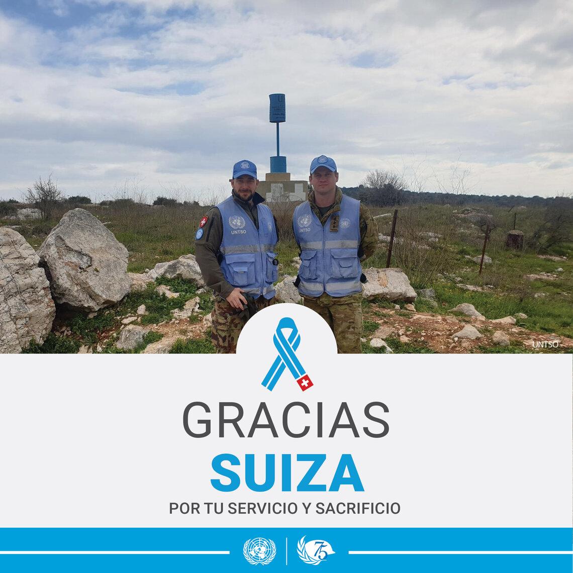 Dos cascos azules mirando a cámara con un paisaje rocoso de fondo.